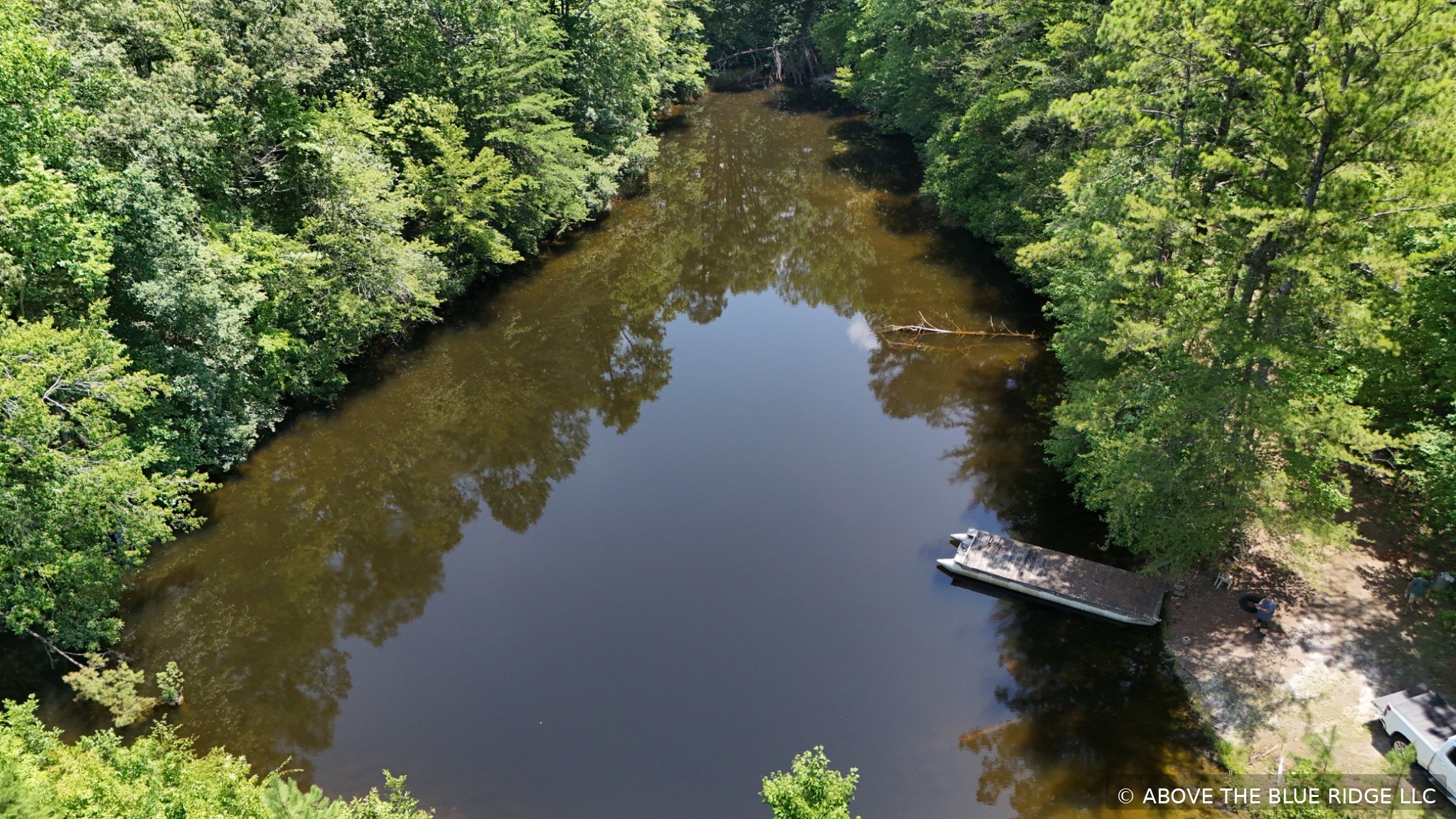 Aerial view of a wooded river and boat